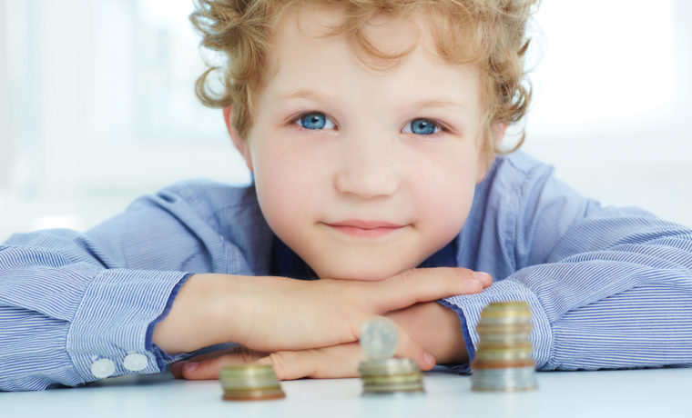The concept of children's economic education. Young boy build a tower by coins.
