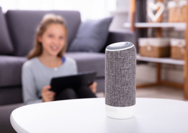 Close-up Of A Wireless Speaker On Furniture With Girl In Background